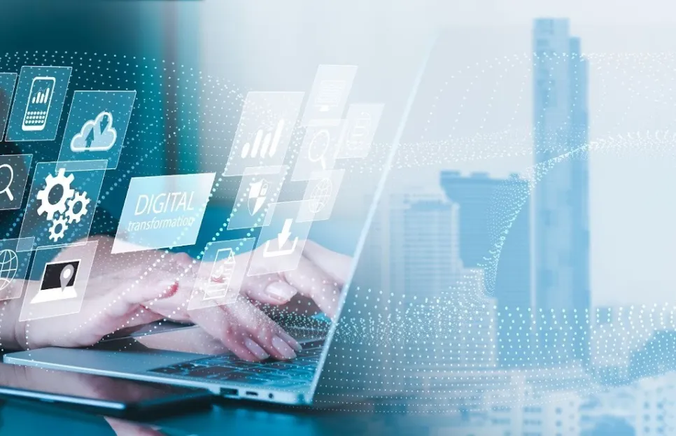 Ruky osoby píšuce na notebooku s prekrytím digitálnych ikon symbolizujúcich cloud, dáta a technológiu v mestskom prostredí