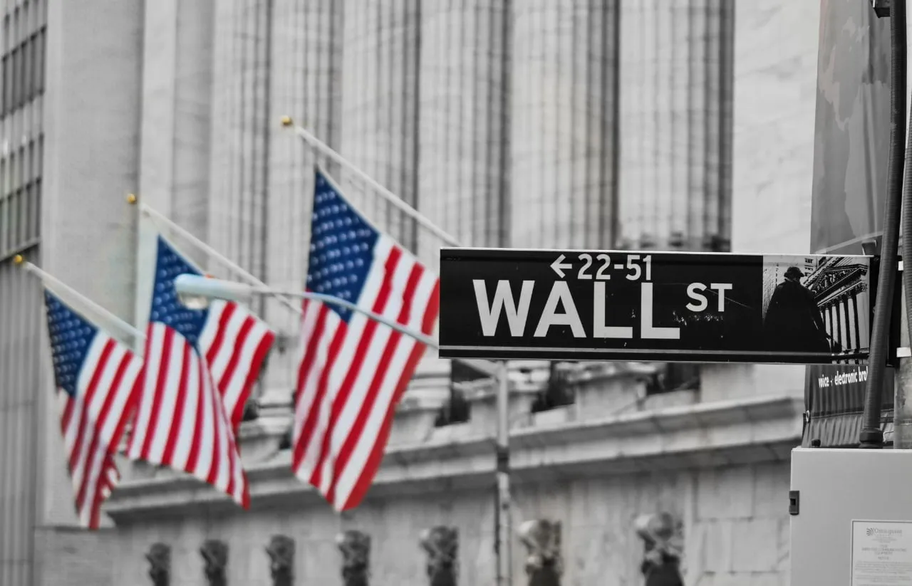 Tabuľa Wall Street s americkými vlajkami v pozadí