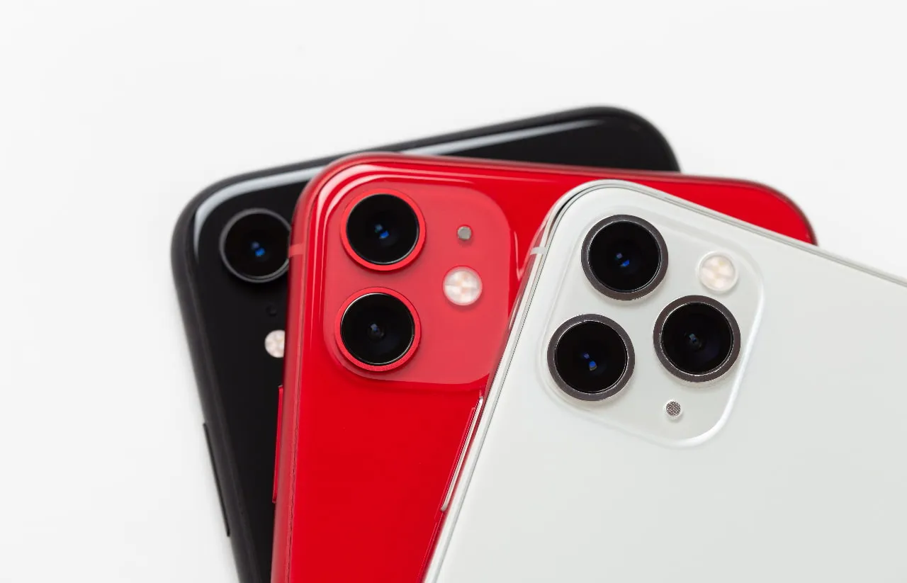 Detailný pohľad na tri smartfóny iPhone v čiernej, červenej a bielej farbe